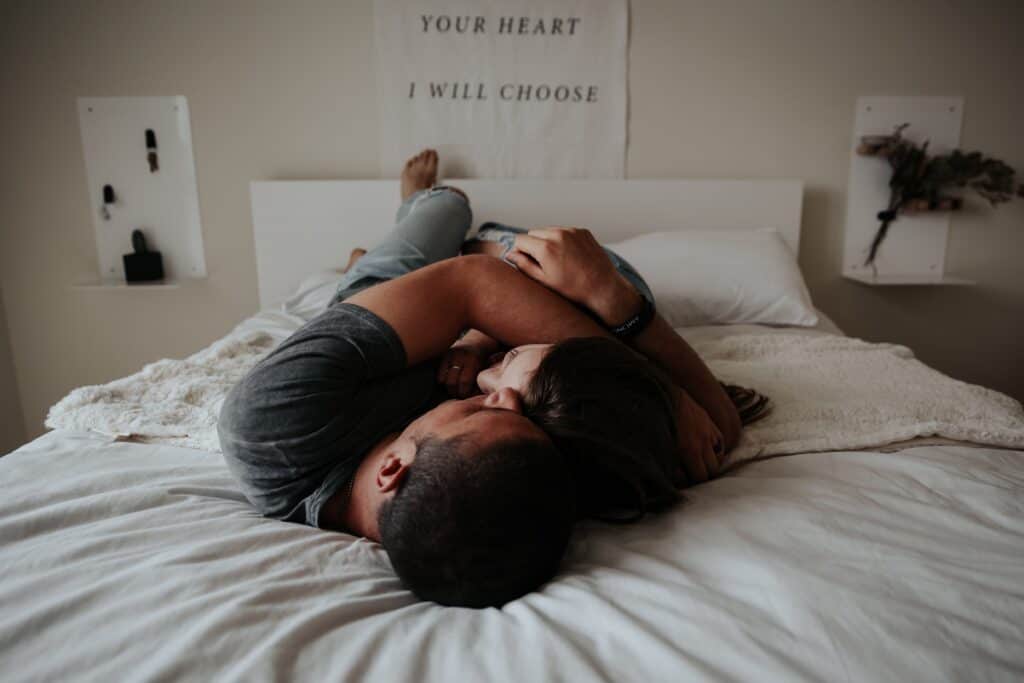 Mann und Frau liegen im Bett und umarmen sich