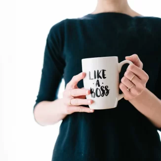 Frau mit einer Tasse, auf der "Like a Boss" steht - Selbstständig nach dem Studium