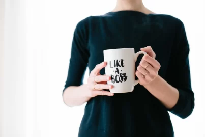 Frau mit einer Tasse, auf der "Like a Boss" steht - Selbstständig nach dem Studium