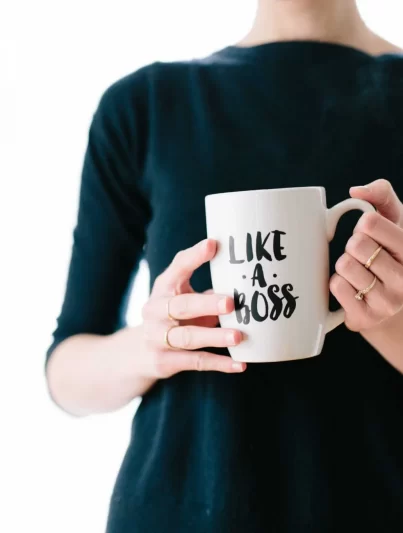 Frau mit einer Tasse, auf der "Like a Boss" steht - Selbstständig nach dem Studium
