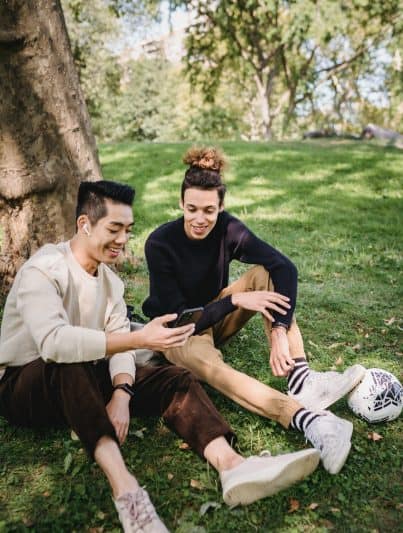 Zwei Studenten die auf ein Smartphone schauen und dabei lächeln