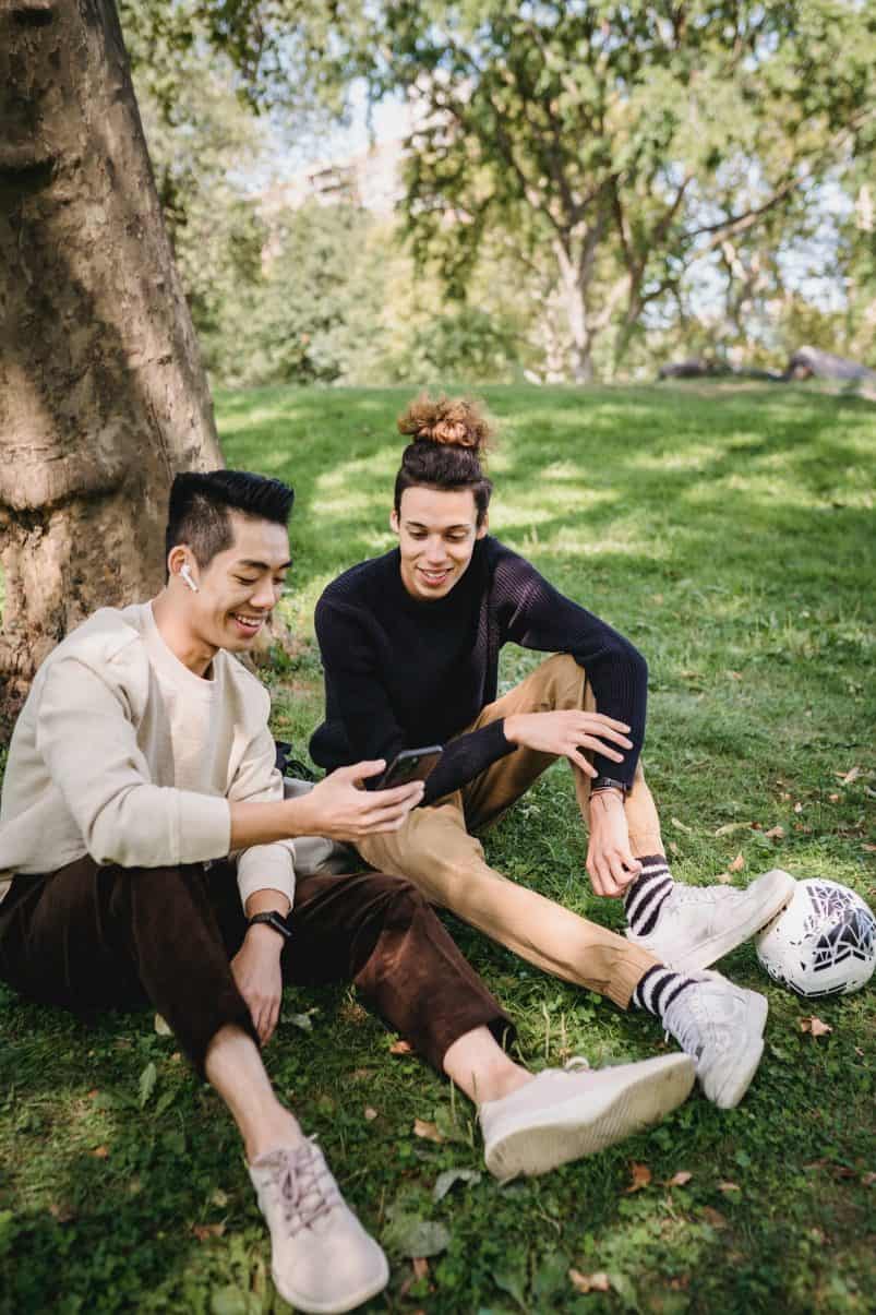 Zwei Studenten die auf ein Smartphone schauen und dabei lächeln