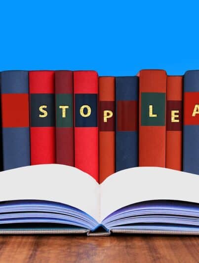 Aneinandergereihte Bücher mit den Initialen „NEVER STOP LEARNING“ und ein aufgeschlagenes Buch