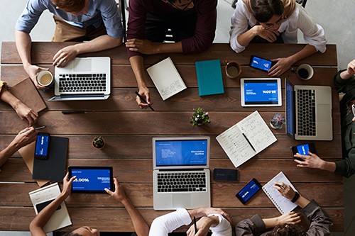 Menschen sitzen an einem Tisch mit ihren Laptops - was soll ich studieren