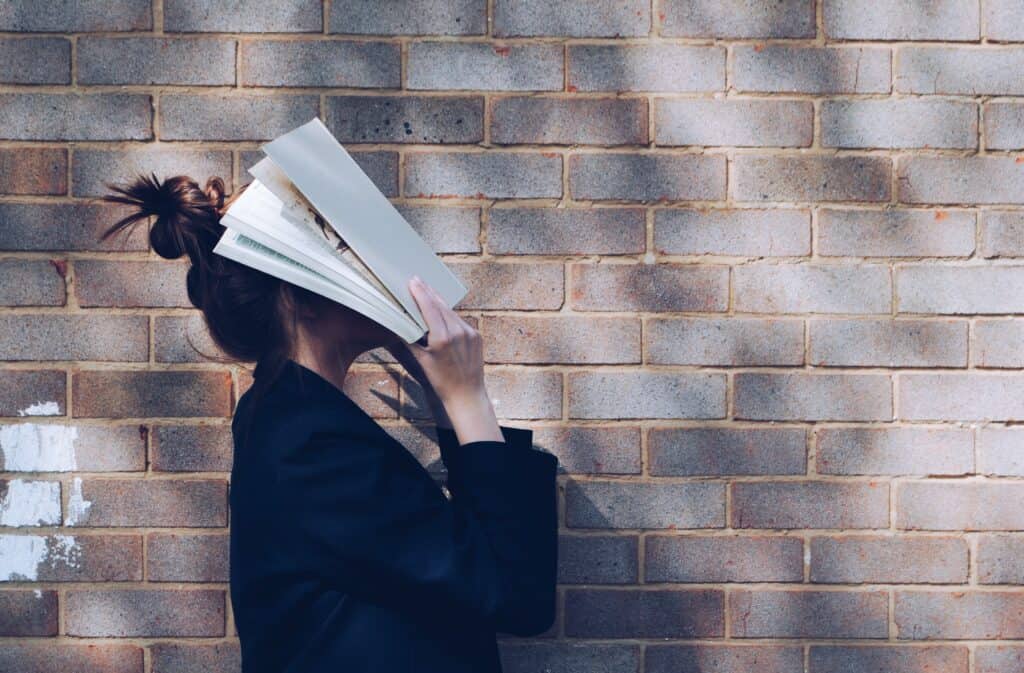 Frau schlägt Buch über Kopf - Tipps für Studierende