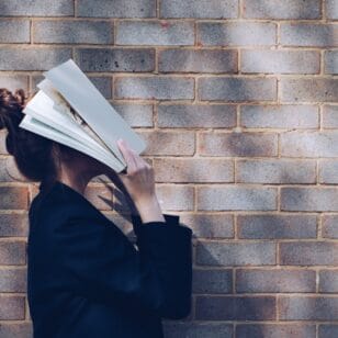 Bildungkarenz Studium - Frau schlägt Buch über Kopf