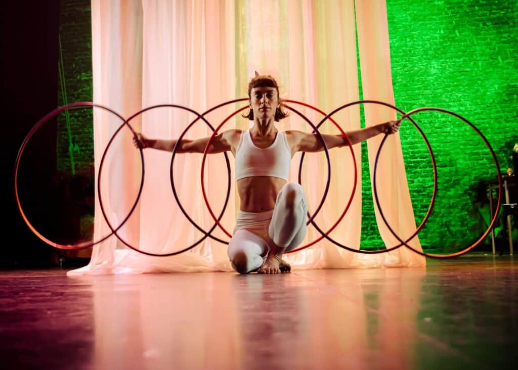 Zirkus-Akrobatin mit sechs Reifen