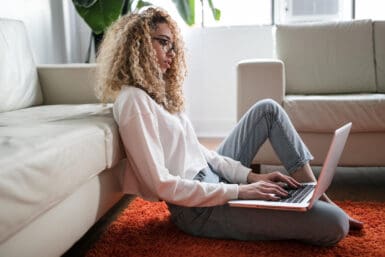 Studentin sitzt mit Laptop auf dem Boden - Generation Z im Studium