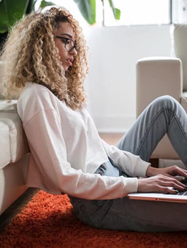 Studentin sitzt mit Laptop auf dem Boden - Generation Z im Studium