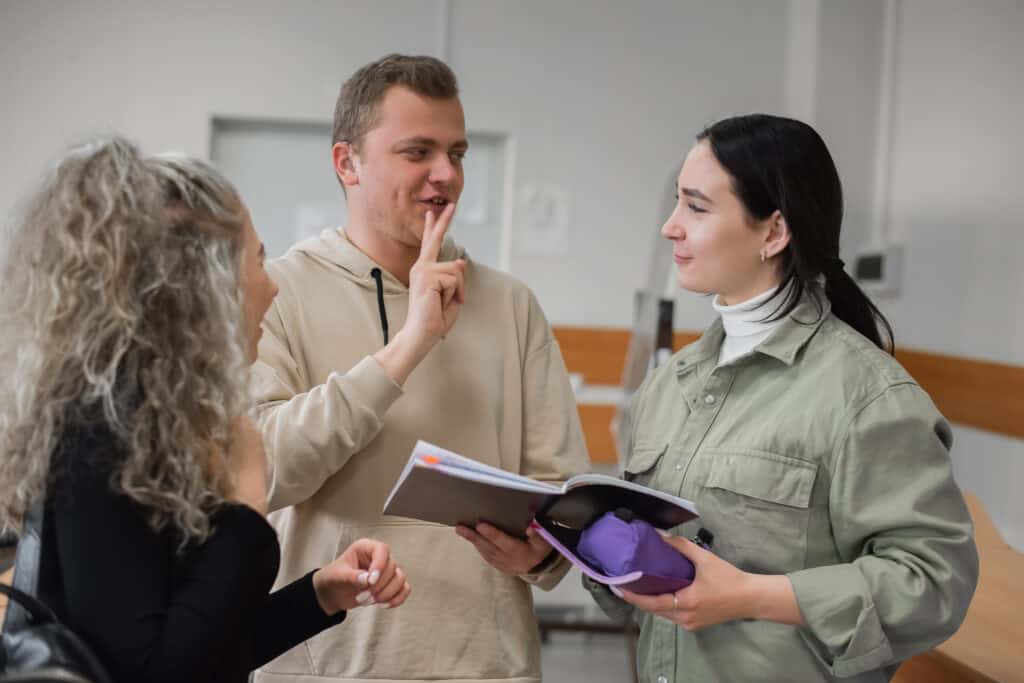 Gehörlose Studierende unterhalten sich in Gebärdensprache.