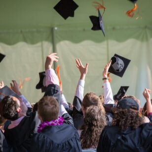 Studierende werfen ihr Kopfbedeckungen in die Luft