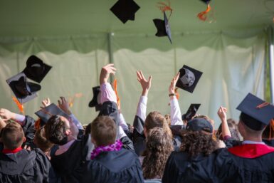 Studierende werfen ihr Kopfbedeckungen in die Luft