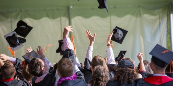 Studierende werfen ihr Kopfbedeckungen in die Luft