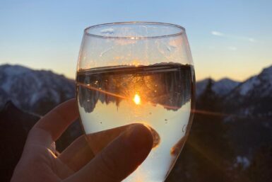 Ein Glas Wein vor einer Kulisse mit Abendstimmung,