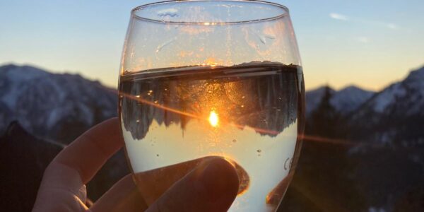 Ein Glas Wein vor einer Kulisse mit Abendstimmung,