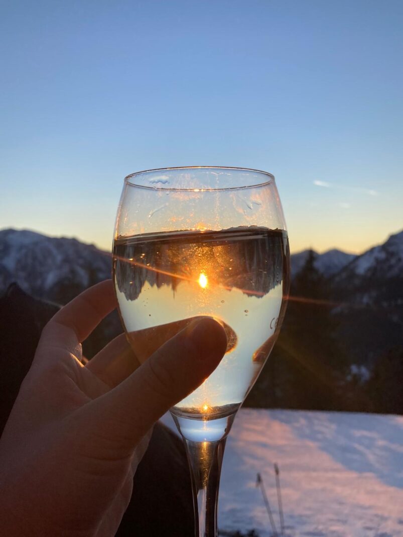 Ein Glas Wein vor einer Kulisse mit Abendstimmung,